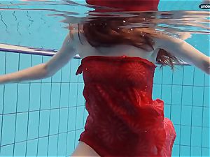 red clad teen swimming with her eyes opened